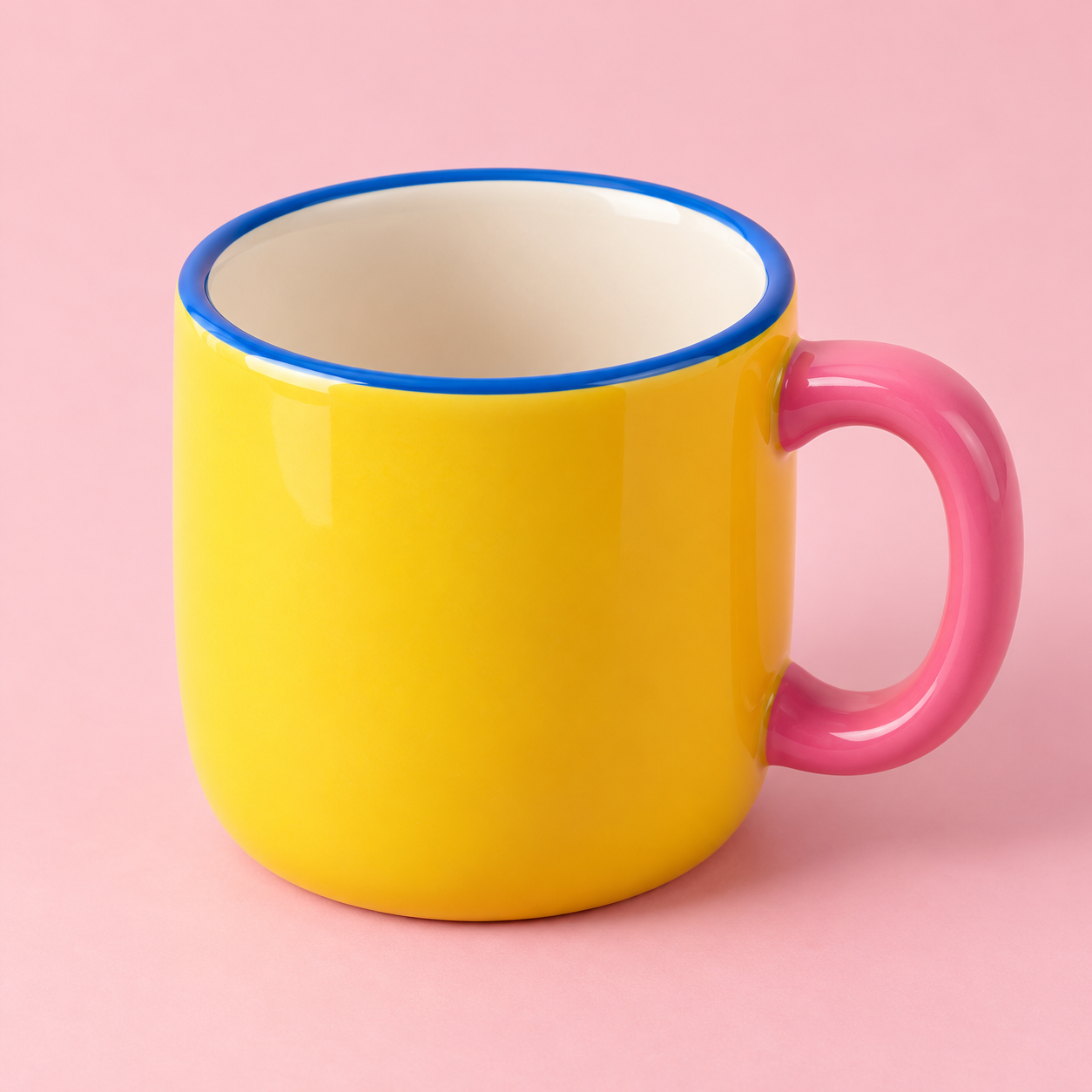 黄色の本体に青い縁とピンクの持ち手を配したマグカップ